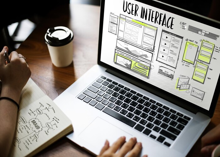 Person an einem Laptop bei der Entwicklung eines User Interfaces