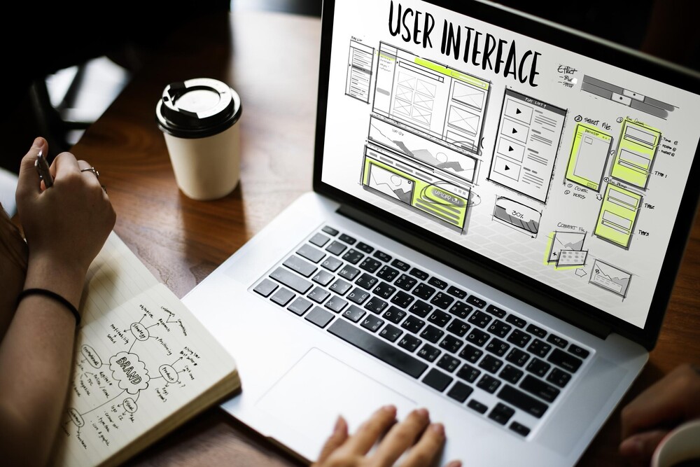 Person an einem Laptop bei der Entwicklung eines User Interfaces