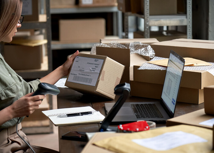 Eine Frau scannt einen Barcode an einem Paket