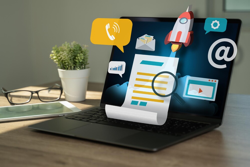 Laptop auf einem Tisch. Darüber schweben verschiedene Icons