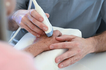 Untersuchung einer Hand mit Ultraschall